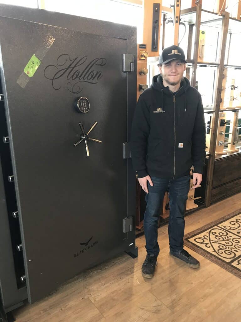 Skyler Miller stands next to a large safe at Keyhole Security in Wenatchee.