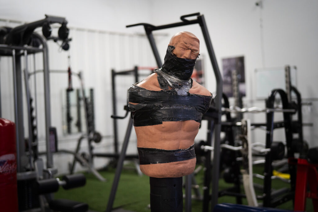 A training dummy with black tape inside a boxing gym
