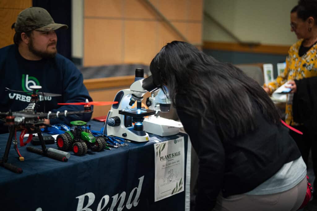 A woman looking into a microscope during the job fair at Big Bend Community College