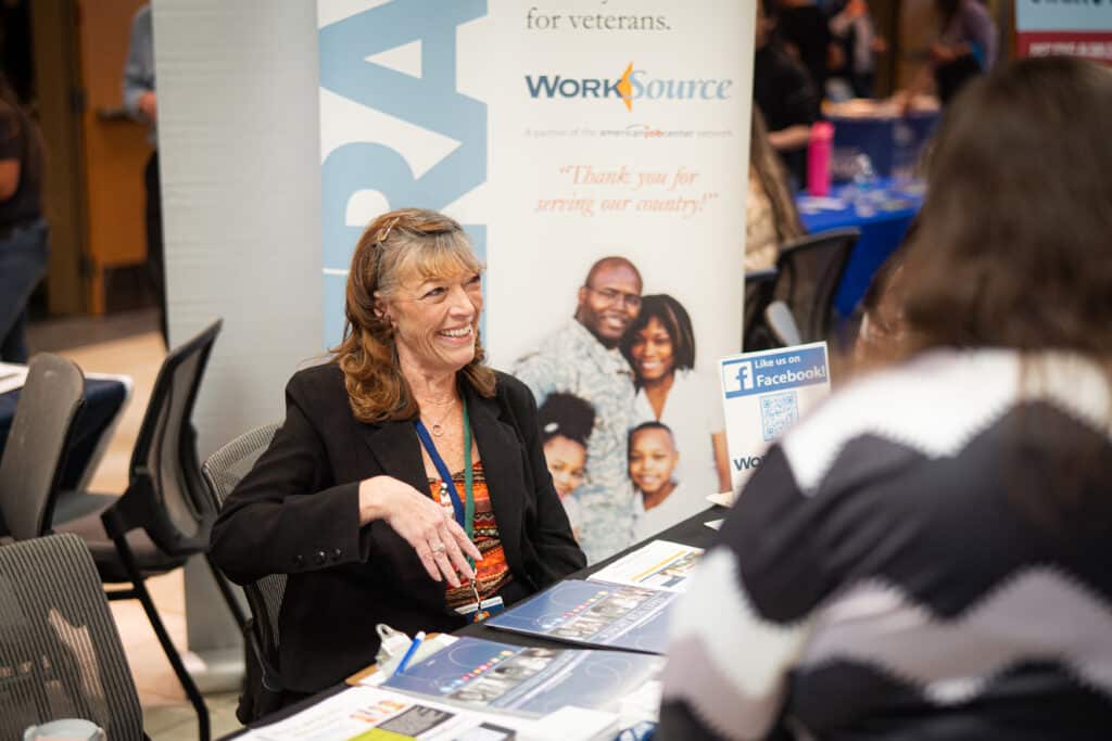 A woman smiling while discussing her services at Big Bend Community College's Job Fair