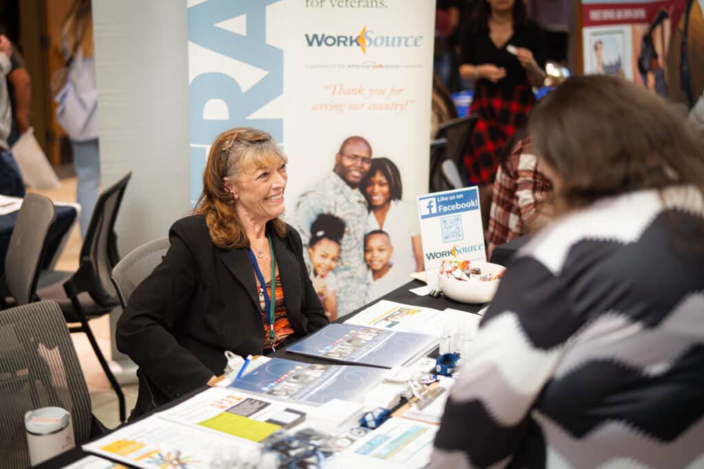 A woman smiling while discussing her services at Big Bend Community College's Job Fair