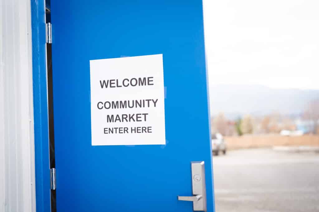 A blue door with a welcome sign to the CDCAC's Food Pantry Event