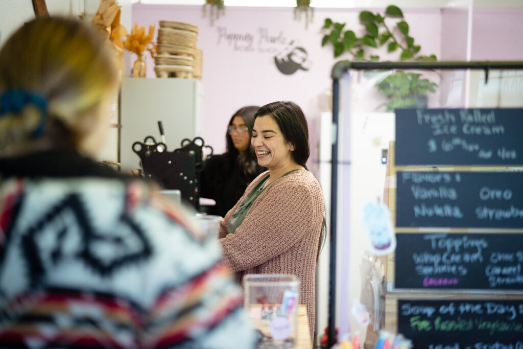Popping Pearls Boba-4 Woman with brunette hair smiling as she prepares a customers order