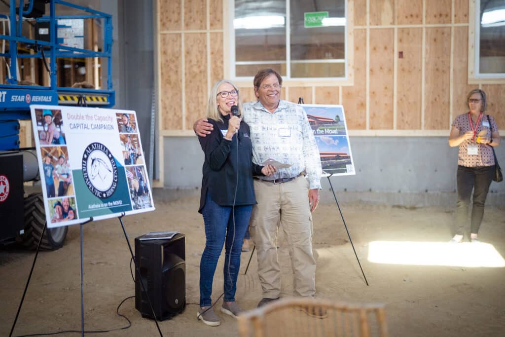 A male and female smiling while doing a presentation together