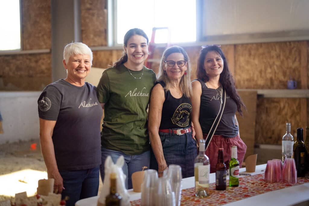 A group of 4 women smiling while looking at the camera