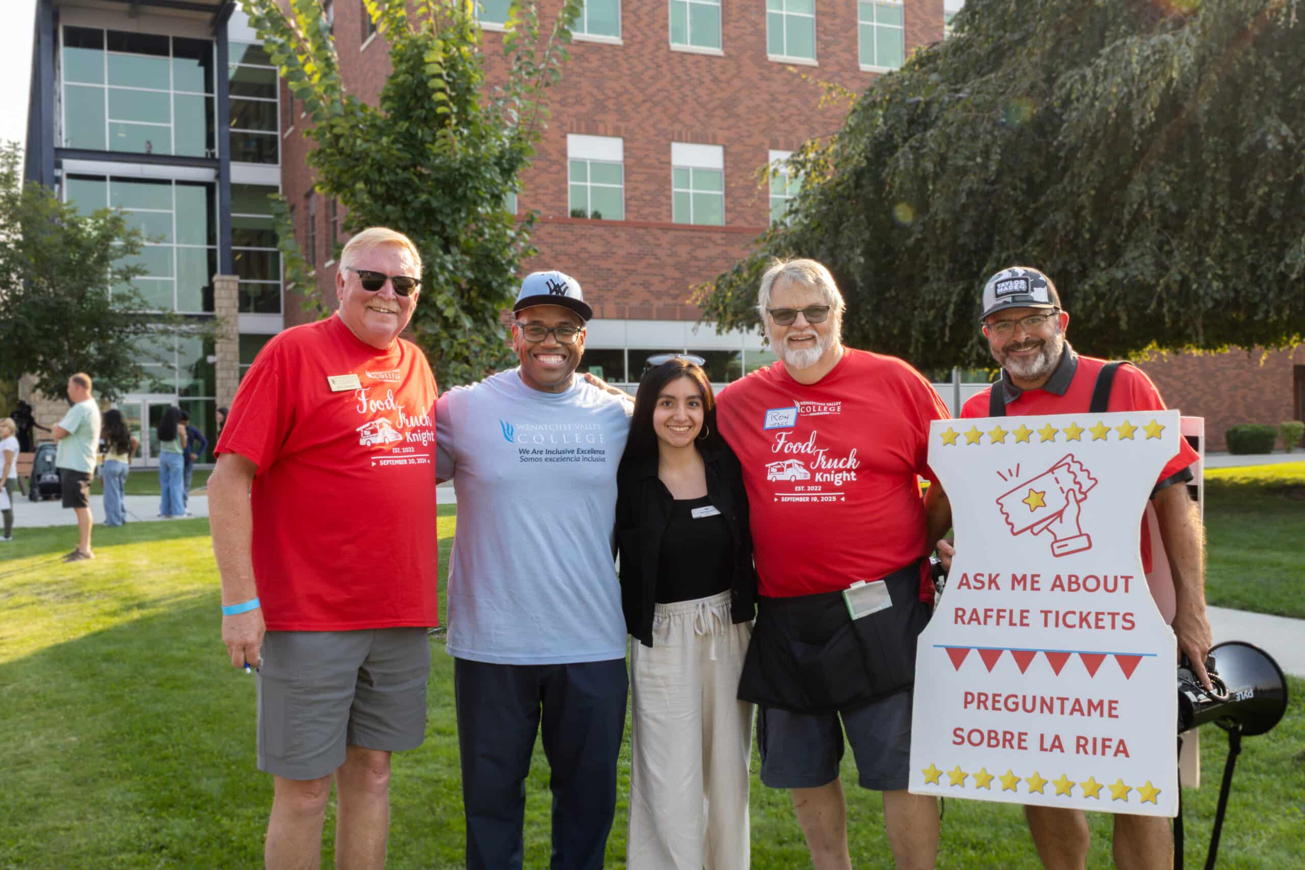 A group of five smiling people stand together on the lawn at Wenatchee Valley College.