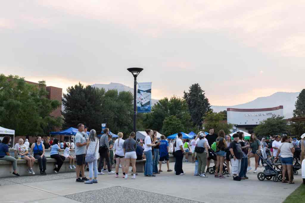 Large group of people gathered outdoors enjoying the evening at Wenatchee Valley College.