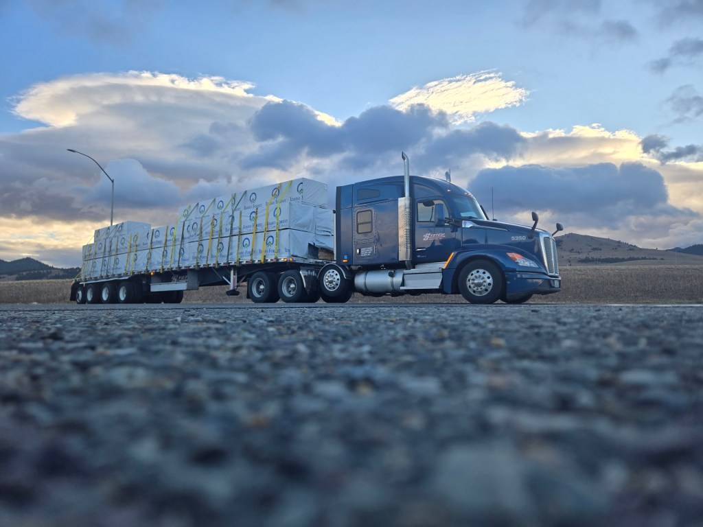 Photo of a truck on the road, outdoors on a gloomy day.