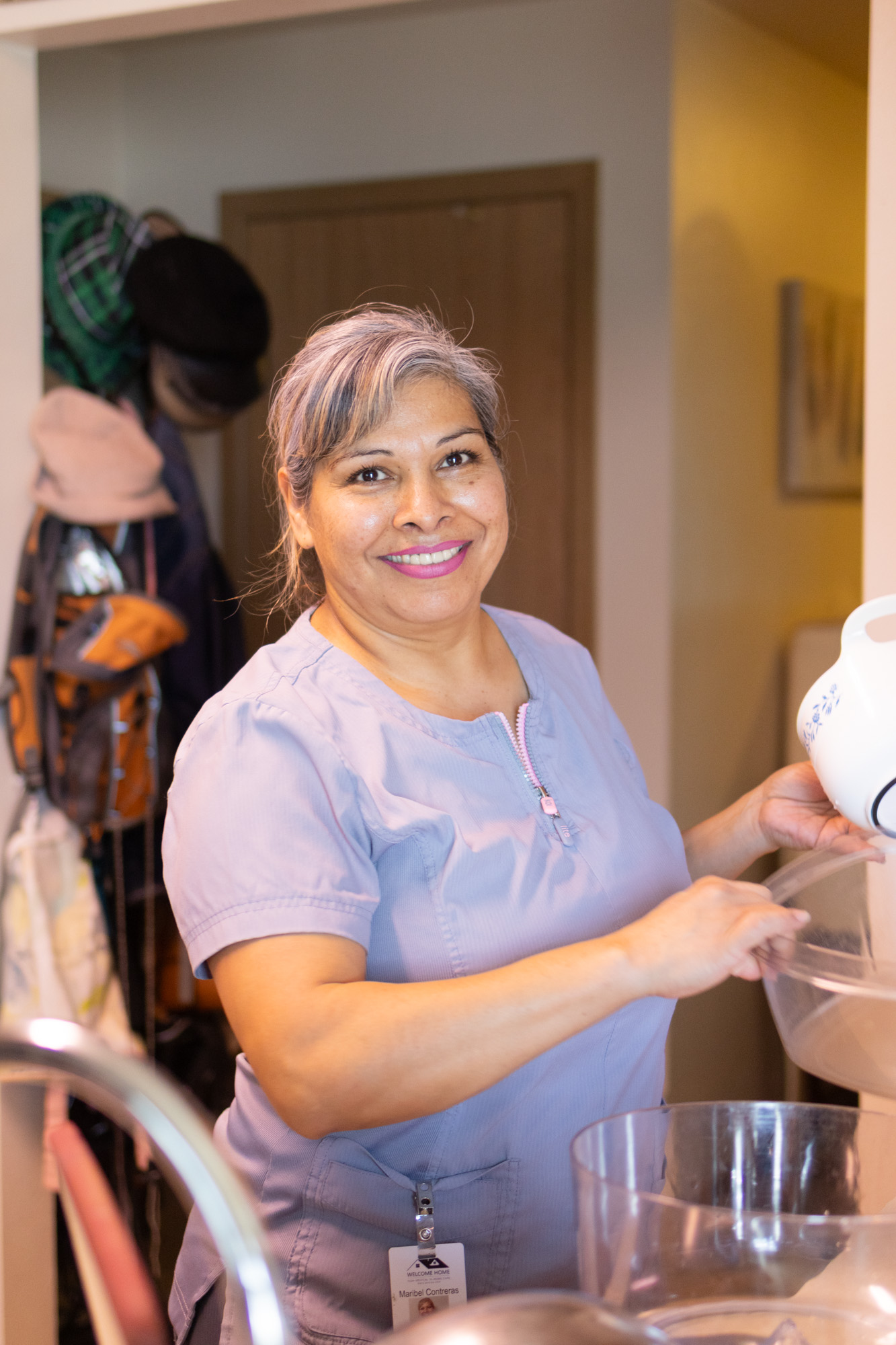 Maribel wearing light purple scrubs, smiling at the camera.