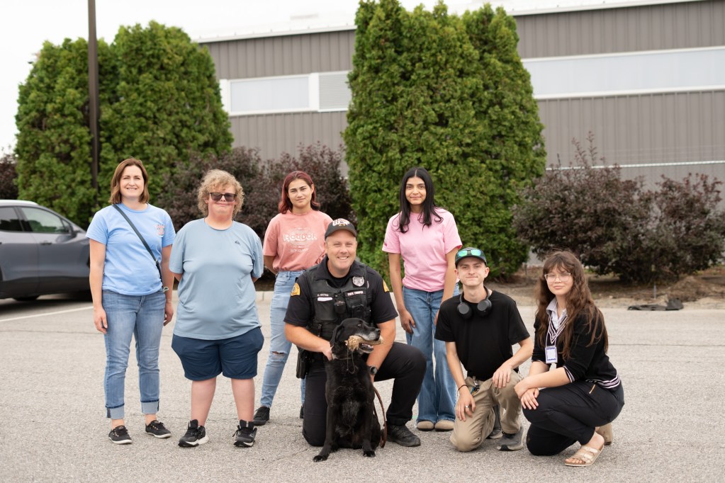 A group of Pre-ETS students and a sheriff with a dog smiling at the camera.